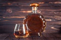 Glass and bottle of whiskey. Decanter with cognac on a dark brown wooden table. Brandy, bourbon. Strong alcohol drink. Rum, scotch Royalty Free Stock Photo