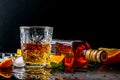 Glass and bottle of whiskey drink with ice cube on black bar background. copy space. concept luxury drink