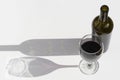 Glass and bottle of wine with dark shadows isolated on a white background