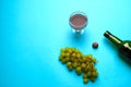 Glass, bottle of wine, green grapes on a blue background Royalty Free Stock Photo