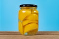 a glass bottle of yellow peach syrup horizontal composition