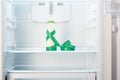 Glass bottle of yoghurt with measuring tape on shelf of open empty refrigerator