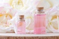 Glass bottles of aroma oil and fresh rose flowers, selective focus Royalty Free Stock Photo