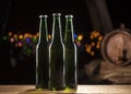 Glass bottles of beer and wooden barrel on bar lights background Royalty Free Stock Photo