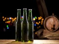 Glass bottles of beer and wooden barrel on bar lights background Royalty Free Stock Photo