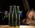 Glass bottles of beer and wooden barrel on bar lights background Royalty Free Stock Photo