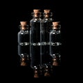 Glass bottles with cork on a black mirror surface with reflections isolated on black Royalty Free Stock Photo