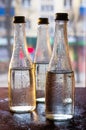 Glass bottles filled with half water in neon light on the background of the view from the window. Selective focus Royalty Free Stock Photo