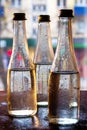 Glass bottles filled with half water in neon light on the background of the view from the window. Selective focus Royalty Free Stock Photo