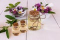 glass bottles filled with organic natural wildflower product on a white wooden table. healing oils. selective focus.