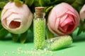 glass bottles with green granules with roses Royalty Free Stock Photo