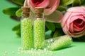 glass bottles with green granules with roses Royalty Free Stock Photo