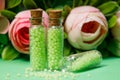 glass bottles with green granules with roses Royalty Free Stock Photo