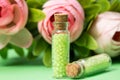 glass bottles with green granules with roses Royalty Free Stock Photo