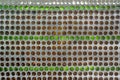 Glass bottles inside the wall background abstract texture. Wall made of beer bottles handmade texture Royalty Free Stock Photo