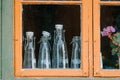 Glass bottles seen through a wooden window.