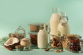 Glass bottles of vegan plant milk and almonds, nuts, coconut, hemp seed milk on blue background. Banner with copy space. Dairy Royalty Free Stock Photo