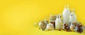 Glass bottles of vegan plant milk and almonds, nuts, coconut, hemp seed milk on yellow background. Banner with copy space. Dairy