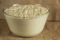 Glass bowl with aired yeast raised dough on paper background Royalty Free Stock Photo