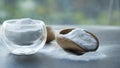 Glass bowl of baking soda. Spoonful of bicarbonate. Royalty Free Stock Photo