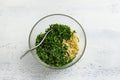 Glass bowl with bulgur and chopped parsley on a light blue background. Cooking Delicious Homemade Vegan Tabbouleh Salad Royalty Free Stock Photo