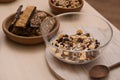 Glass bowl with cereal and grains on table. Healthy granola bar preparation Royalty Free Stock Photo