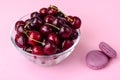 Glass bowl with cherry on pink background Royalty Free Stock Photo