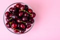 Glass bowl with cherry on pink background Royalty Free Stock Photo