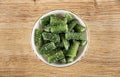 Glass bowl with marmalade in form green bean on wooden table. Top view Royalty Free Stock Photo