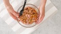 Glass bowl with the chopped marinated chicken meat mixture inside close-up in woman's hands Royalty Free Stock Photo