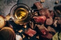 Glass bowl containing olive oil and small beef cubes and potatoes on a black board Royalty Free Stock Photo