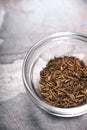 Glass bowl with cumin on the table partial blur