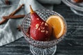 Glass bowl with delicious poached pear in red wine on wooden table Royalty Free Stock Photo