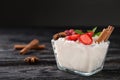 Glass bowl with delicious rice pudding and berries on black wooden table Royalty Free Stock Photo