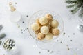 Glass bowl with delicious white chocolate candies, truffles in coconut and ground nuts on light blue background with New Year`s Royalty Free Stock Photo