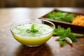 glass bowl of edamame soup with sprig of cilantro Royalty Free Stock Photo