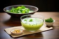 glass bowl of edamame soup with sprig of cilantro Royalty Free Stock Photo