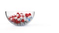Glass bowl filled with bunch of red and blue pills - isolated on white background Royalty Free Stock Photo