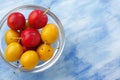 Glass bowl filled by yellow and red mirabelle plums