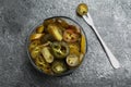 Glass bowl and fork with slices of pickled green jalapeno peppers on grey table, flat lay