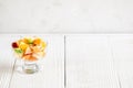 Glass bowl with fruit salad is standing on white wooden table. Royalty Free Stock Photo