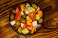 Glass bowl with greek salad on wooden table. Top view Royalty Free Stock Photo