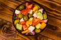 Glass bowl with greek salad on wooden table. Top view Royalty Free Stock Photo