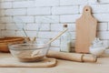 Glass bowl with groats and various kitchen utensils and dishware on wooden table