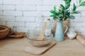Glass bowl with groats and various kitchen utensils and dishware on wooden table Royalty Free Stock Photo