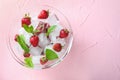 Glass bowl with ice cubes and strawberries on color background Royalty Free Stock Photo