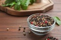 Glass bowl of mixed pepper corns on wooden table Royalty Free Stock Photo