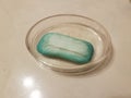 Glass bowl with old blue soap on bathroom counter Royalty Free Stock Photo