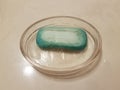 Glass bowl with old blue soap on bathroom counter Royalty Free Stock Photo