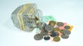 Glass bowl with piles of coins and Malaysia bank notes. Royalty Free Stock Photo